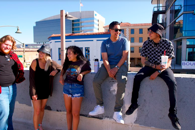 group of young adults talking to eachother on a rooftop in downtown Tucson