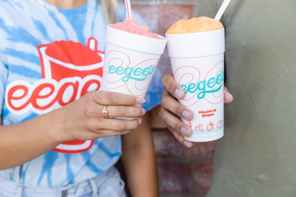 couple of young adults holding their eegee drinks 
