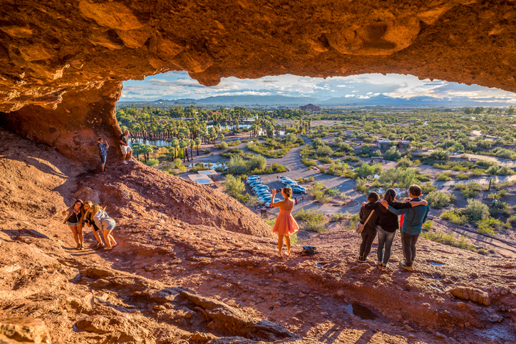 People snap pictures of themselves in the mouth of Hole-in-the-Rock, a tourist attraction in Papago Park, Arizona. It was once used by the ancient Hohokam people to mark the turn of the seasons.