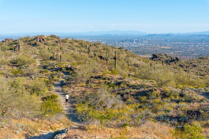 A man hikes a trail on South Mountain that overlooks the city of Phoenix.